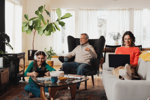 A family gathered on couches in a cozy living room, enjoying each other's company and sharing smiles
