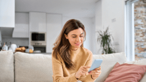 A woman on a couch, engaged with her phone, appearing relaxed and comfortable